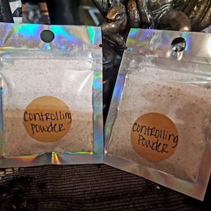 May include: Two small clear plastic bags with a silver iridescent finish. Each bag contains a white powder and a round brown label that reads "Controlling Powder".