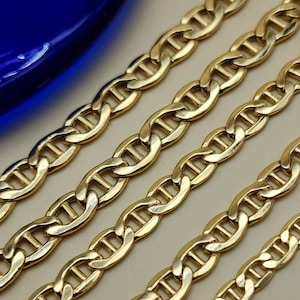 May include: Four gold chains of different widths, all featuring a mariner link design. The chains are arranged in a row, with the widest chain at the top and the narrowest chain at the bottom.