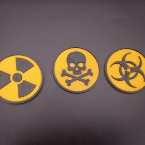 May include: Three yellow and black warning signs. The first sign has a black radiation symbol, the second sign has a black skull and crossbones, and the third sign has a black biohazard symbol.