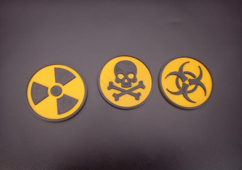 May include: Three yellow and black warning signs. The first sign has a black radiation symbol, the second sign has a black skull and crossbones, and the third sign has a black biohazard symbol.