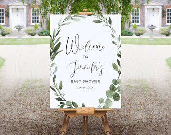 May include: A white welcome sign with a green leafy wreath border. The sign reads "Welcome to Jennifer's Baby Shower Jun 24, 20XX".