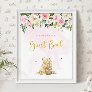 Puede incluir: Un cartel de libro de visitas floral rosa y blanco con una ilustraci&oacute;n de Winnie the Pooh. El cartel dice "Por favor, firme nuestro libro de visitas" en letras doradas. Winnie the Pooh est&aacute; sosteniendo un tarro de miel y hay abejas volando a su alrededor.