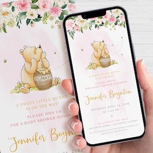 K&ouml;nnte beinhalten: Eine rosa und wei&szlig;e Babyparty-Einladung mit einem floralen Rand. Die Einladung zeigt einen Winnie Puuh-Cartoon, der ein Honigglas h&auml;lt. Der Text auf der Einladung lautet: "Ein s&uuml;&szlig;er kleiner Honig ist auf dem Weg! Bitte schlie&szlig;en Sie sich uns zu einer Babyparty zu Ehren von Jennifer Boynton an. Samstag, 24. April 20XX um 14:00 Uhr. The Hundred Acre Wood, 8635 Wood Avenue, Kalifornien, CA 68485. RSVP an Madelyn unter 123-456-7890 oder Madelyn@email.com. Registriert bei Amazon & Target."