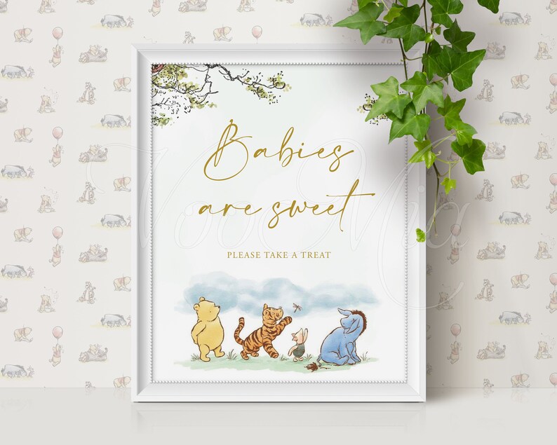 K&ouml;nnte beinhalten: Ein wei&szlig;er gerahmter Druck mit Winnie Puuh-Motiv. Der Druck zeigt Winnie Puuh, Ferkel, Tigger und Esel, die auf einem Feld stehen. Der Text auf dem Druck lautet "Babies are sweet. Please take a treat."