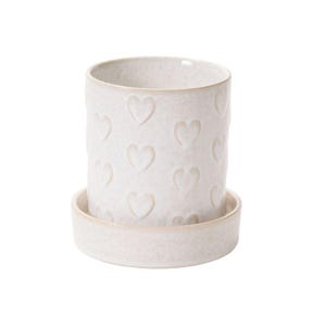 May include: White ceramic planter with a heart pattern. The planter has a matching saucer.