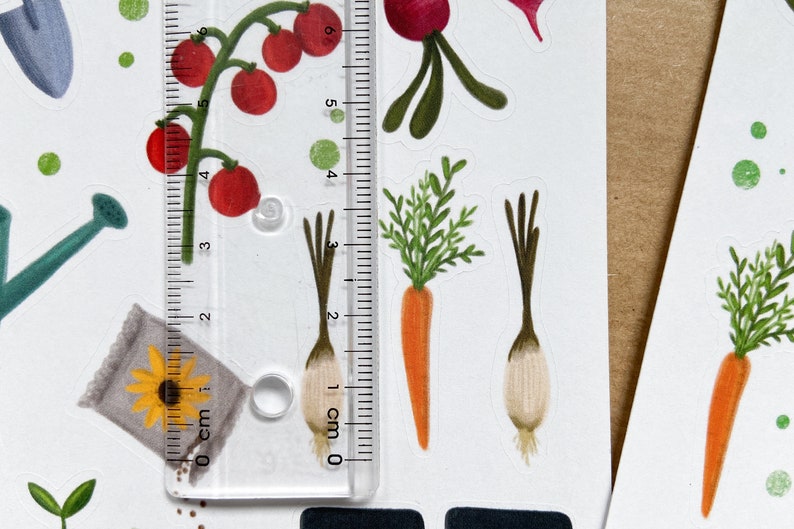May include: A set of colorful stickers featuring various vegetables, including carrots, onions, and tomatoes. The stickers are arranged on a white background with a ruler measuring 6 cm.