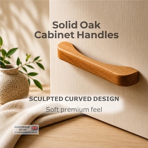 Può includere: Maniglia per armadio in legno massello di rovere con un design scolpito e curvo. La maniglia è di colore marrone chiaro ed è attaccata a un'anta dell'armadio di colore chiaro. Testo: "Solid Oak Cabinet Handles".