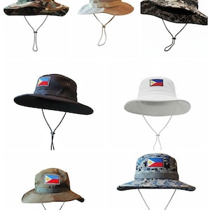 May include: Collection of eight bucket hats in various colors and patterns, each featuring the flag of the Philippines. The hats have a wide brim and an adjustable chin strap. Camouflage, black, white, and tan hats are shown.