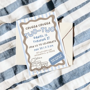 May include: A birthday party invitation with the text "CHUGGA CHUGGA TWO-TWO" and "DANIEL IS TURNING 2!". The invitation has a train graphic and includes the date, time, and location. An envelope is included.