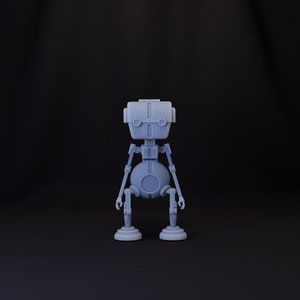 Pode incluir: Um brinquedo robô cinza com um corpo redondo e dois braços. O robô tem uma cabeça retangular com dois olhos pretos e uma pequena boca.