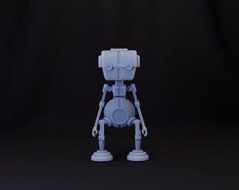 May include: A gray robot toy with a round body and two arms. The robot has a rectangular head with two black eyes and a small mouth.