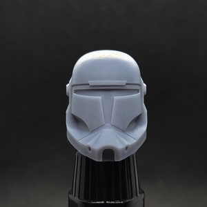 May include: A gray plastic 3D printed helmet with a visor and a textured surface.