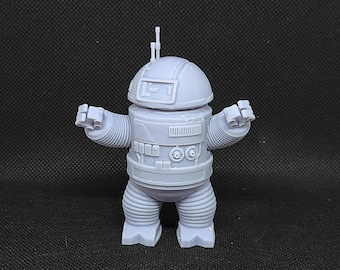 May include: A gray 3D printed robot figurine with a round head, two antennas, and outstretched arms. The robot has a segmented body and legs.