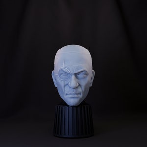 Puede incluir: Un busto de yeso blanco de la cabeza de un hombre con un parche en un ojo. El busto está sobre un pedestal negro.