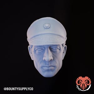 May include: A light blue bust of a man wearing a military-style cap with a circular emblem. The bust has detailed facial features and is set against a black background. The text "@BOUNTYSUPPLYCO" is at the bottom left.