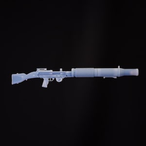 May include: A white plastic toy gun with a long barrel and a ribbed texture. The gun has a black handle and a black trigger.