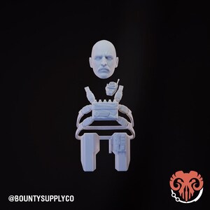 May include: A light blue 3D-printed action figure set, featuring a bald head with a mustache, a tactical vest, and two pouches. A small radio is attached to the vest. The text "@BOUNTYSUPPLYCO" is at the bottom.
