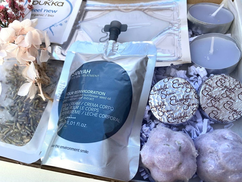 Pu&ograve; includere: Una confezione regalo con prodotti per la spa. Include una bustina di crema corpo, due bombe da bagno color lavanda, due piccole candele e due cioccolatini Elizabeth Shaw. Contiene anche fiori secchi e una bustina di t&egrave;.