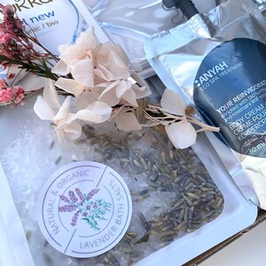 Pu&ograve; includere: Una confezione regalo contenente prodotti per la spa, tra cui sali da bagno alla lavanda, una crema corpo e fiori secchi. La crema corpo &egrave; etichettata "Your Reinvigoration" ed &egrave; da 30 ml. I sali da bagno sono etichettati "Natural & Organic Lavender Bath Salts."