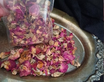 Puede incluir: Primer plano de una bandeja plateada llena de pétalos de rosa secos. Los pétalos son una mezcla de rosa, rojo y marrón. Los pétalos están en una bolsa de plástico transparente.