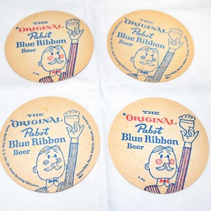 Puede incluir: Cuatro posavasos de cerveza Pabst Blue Ribbon vintage. Cada posavasos presenta una ilustración de dibujos animados de un hombre sosteniendo una cerveza, con el texto "The Original Pabst Blue Ribbon Beer" en azul y rojo.