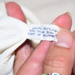 May include: White tag with blue text that reads "100% NYLON WPL 27249 SIZE MADE IN PHILIPPINES".