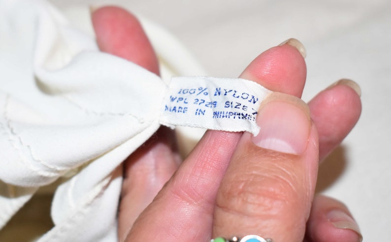 May include: White tag with blue text that reads "100% NYLON WPL 27249 SIZE MADE IN PHILIPPINES".