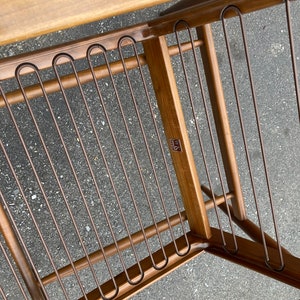 May include: A wooden chair with a metal frame and a brown finish. The chair has a label that says "MASCO" on it.