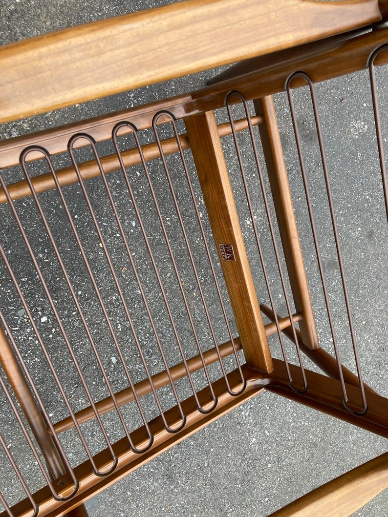 May include: A wooden chair with a metal frame and a brown finish. The chair has a label that says "MASCO" on it.
