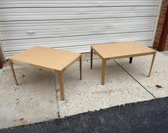 May include: Two wooden end tables with a light brown finish and a rectangular top. The tables have a simple, modern design with a square base.