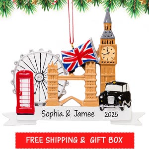 May include: A London-themed Christmas ornament featuring a red telephone booth, the London Eye, Tower Bridge, Big Ben, a black taxi, and a Union Jack flag. The ornament is personalized with the names "Sophia & James" and the year "2025".