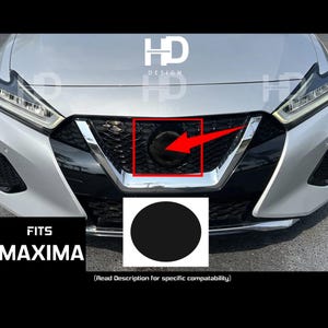 May include: A silver Nissan Maxima with a black grille and a black emblem. The text "FITS MAXIMA" is visible below the image. The text "(Read Description for specific compatibility)" is visible below the text "FITS MAXIMA".