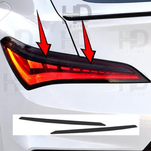 May include: A white car features a red LED taillight assembly with a dark tinted horizontal strip. Two red arrows point toward the dark strip on the taillight. Below, two separate black adhesive strips are shown as individual components.