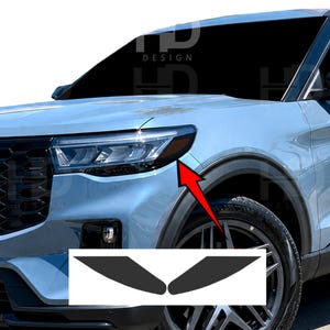 May include: A light blue SUV front end featuring a sleek headlight assembly with an amber side marker. A red arrow points from the headlight to a pair of dark, almond-shaped vinyl overlays designed to cover the amber reflector section.