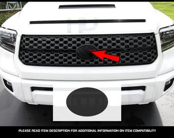 Puede incluir: Una camioneta blanca con una parrilla negra y un emblema ovalado negro. El emblema está ubicado en el centro de la parrilla.