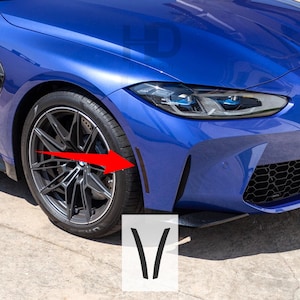 May include: A blue car with black trim around the wheel wells and front bumper. The car has a black grille and black headlights. The car is parked on a black surface.