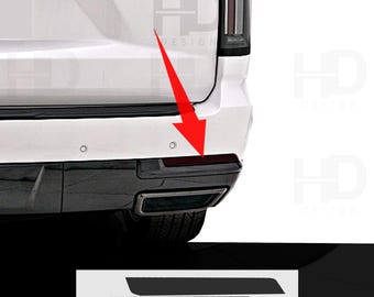May include: Black bumper trim pieces for a vehicle, shown against a white background. The trim pieces are rectangular and angled. The image also shows the rear of a white vehicle with a black bumper.