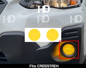 May include: A pair of circular yellow adhesive film overlays designed for vehicle fog lights. The product is shown applied to a white car bumper, featuring a bright yellow tint over the circular light housing, with two additional yellow circles.