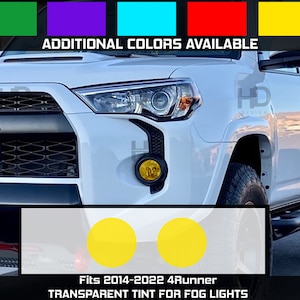 May include: A white Toyota 4Runner with yellow fog light covers. The image shows the front of the vehicle with the fog lights and the Toyota logo. The text "Fits 2014-2022 4Runner TRANSPARENT TINT FOR FOG LIGHTS" is at the bottom of the image.