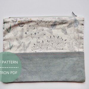 May include: A grey and white zippered pouch with a floral print and a solid grey bottom. The pouch has a zipper closure and the text "PDF PATTERN" and "PATRON PDF" is printed on a green circle.