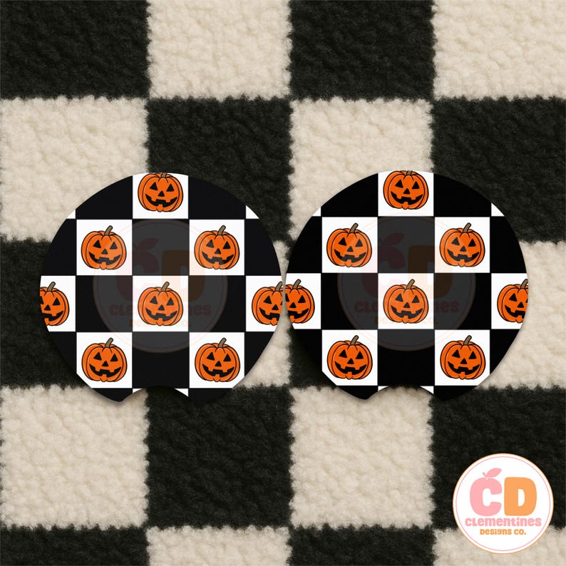 May include: Two round car coasters with a black and white checkered pattern. Each coaster features a grid of orange jack-o'-lanterns. The background is a black and white checkered pattern.