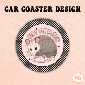May include: A round car coaster with a black and white checkered border. The center of the coaster is pink with a cartoon opossum and the text "Cute But Trashy".