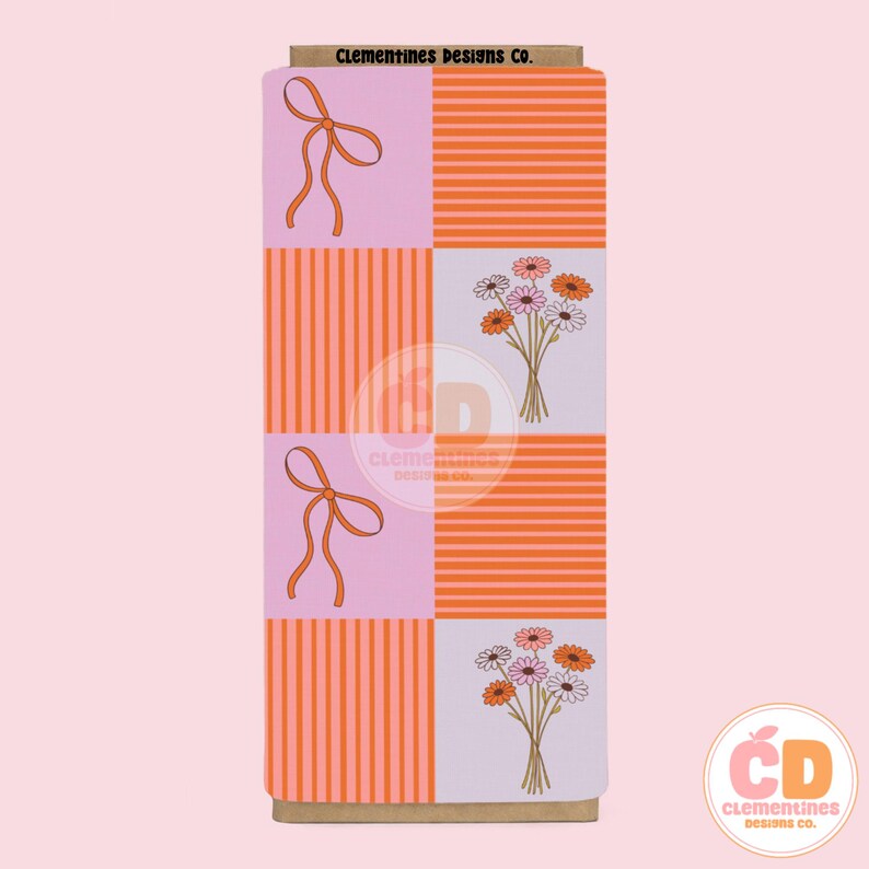 May include: A rectangular box with a repeating pattern of pink squares with orange bows, orange striped squares, and squares with bouquets of daisies. The top of the box has the text "Clementines Designs Co."