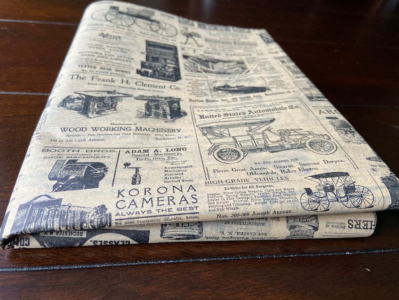 May include: A vintage style brown paper with black text and images. The paper features advertisements for various products, including wood working machinery, cameras, and automobiles. The text includes the names of companies such as "Booth Bros", "Adam A. Long", "Korona Cameras", and "United States Automobile Co.".