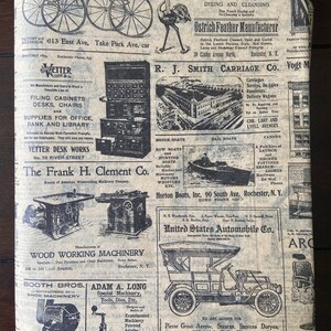 May include: A vintage newspaper clipping with advertisements for various businesses, including carriage makers, boat builders, wood working machinery, shoe machinery, cameras, and automobiles. The newspaper is printed on brown paper with black ink.