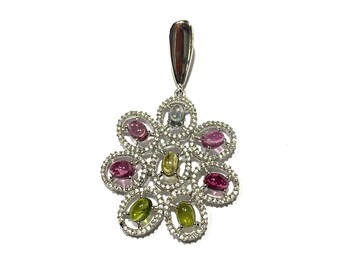 May include: A silver pendant with a flower design featuring a variety of colorful gemstones, including pink, green, yellow, and blue.