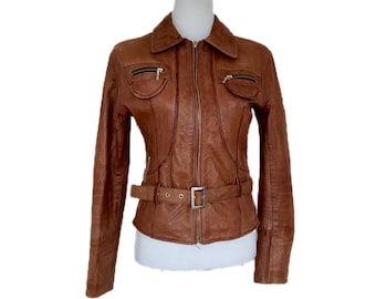 Könnte beinhalten: Braune Lederjacke mit Kragen, zwei Brusttaschen mit Reißverschluss und einem Gürtel in der Taille. Die Jacke hat einen Reißverschluss und lange Ärmel. Die Jacke wird auf einer weißen Schaufensterpuppe präsentiert.