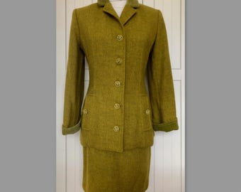 May include: A green wool suit with a skirt and jacket. The jacket has a velvet collar and gold buttons.