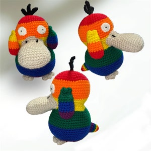 May include: Three crocheted rainbow-colored bird plushies. Each plush has a different pose. One is standing upright, one is sitting, and one is lying down.