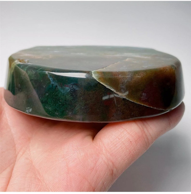 May include: A smooth, polished, green, brown, and white agate stone with a rounded, oval shape. The stone is a natural, polished, and smooth, decorative object.